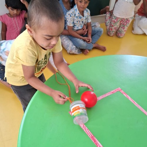 Teacher guiding children in a creative classroom activity at Waddle Kids Medavakkam