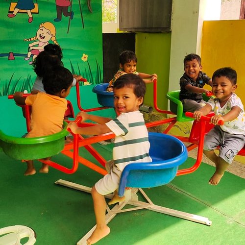 Children enjoying a merry-go-round during an outdoor event at Waddle Kids Chennai